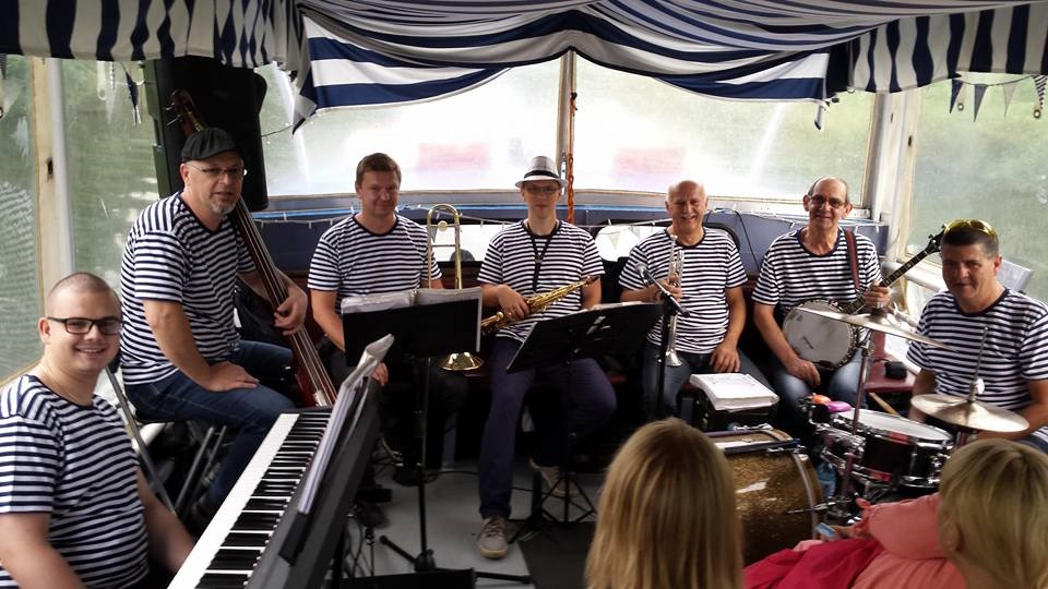 South Silesian Brass Band/fot. materiały organizatora Członkowie zespołu siedzą z instrumentami, mają na sobie koszulki w biało-granatowe paski