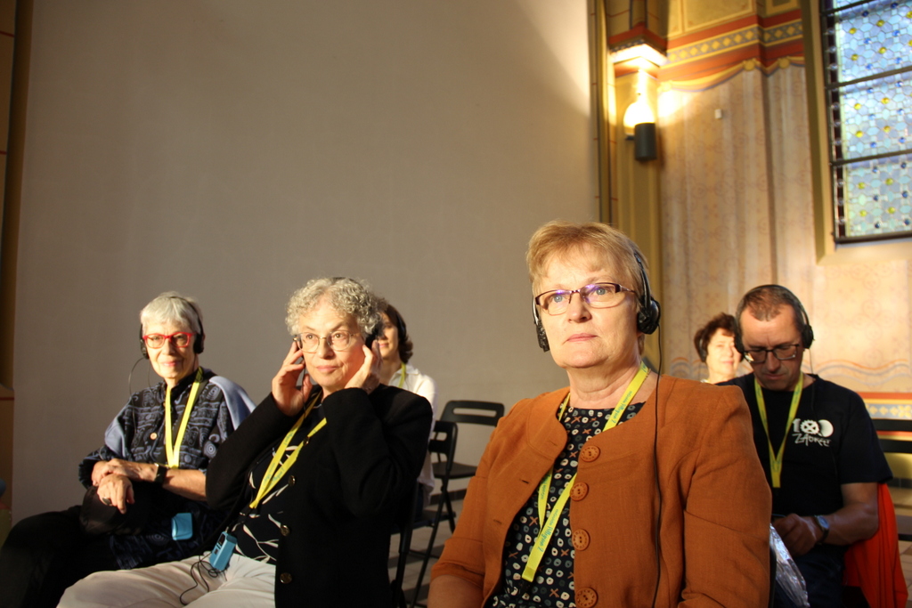 Uczestnicy konferencji w słuchawkach na uszach