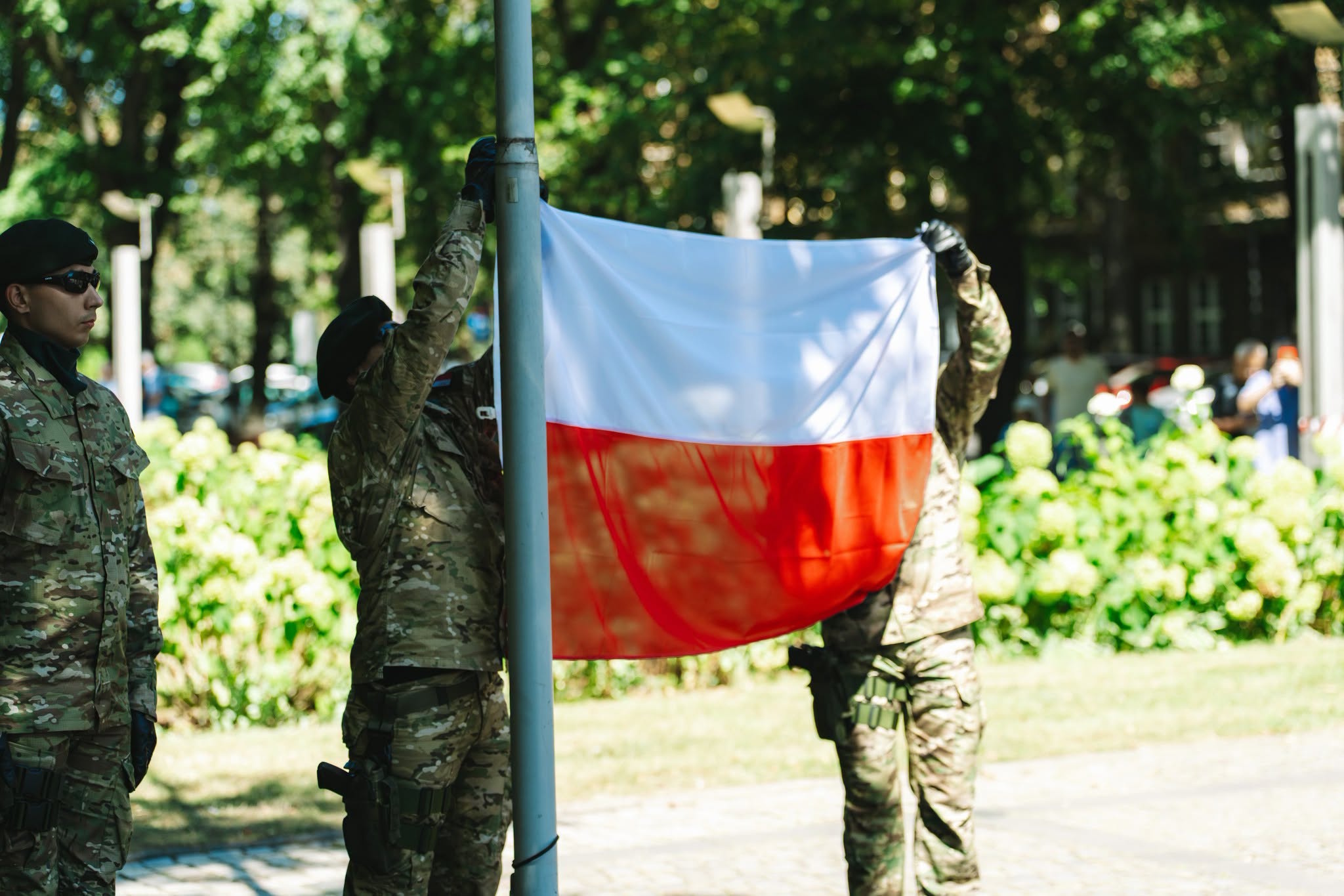 Żołnierze wnoszący polską flagę na maszt