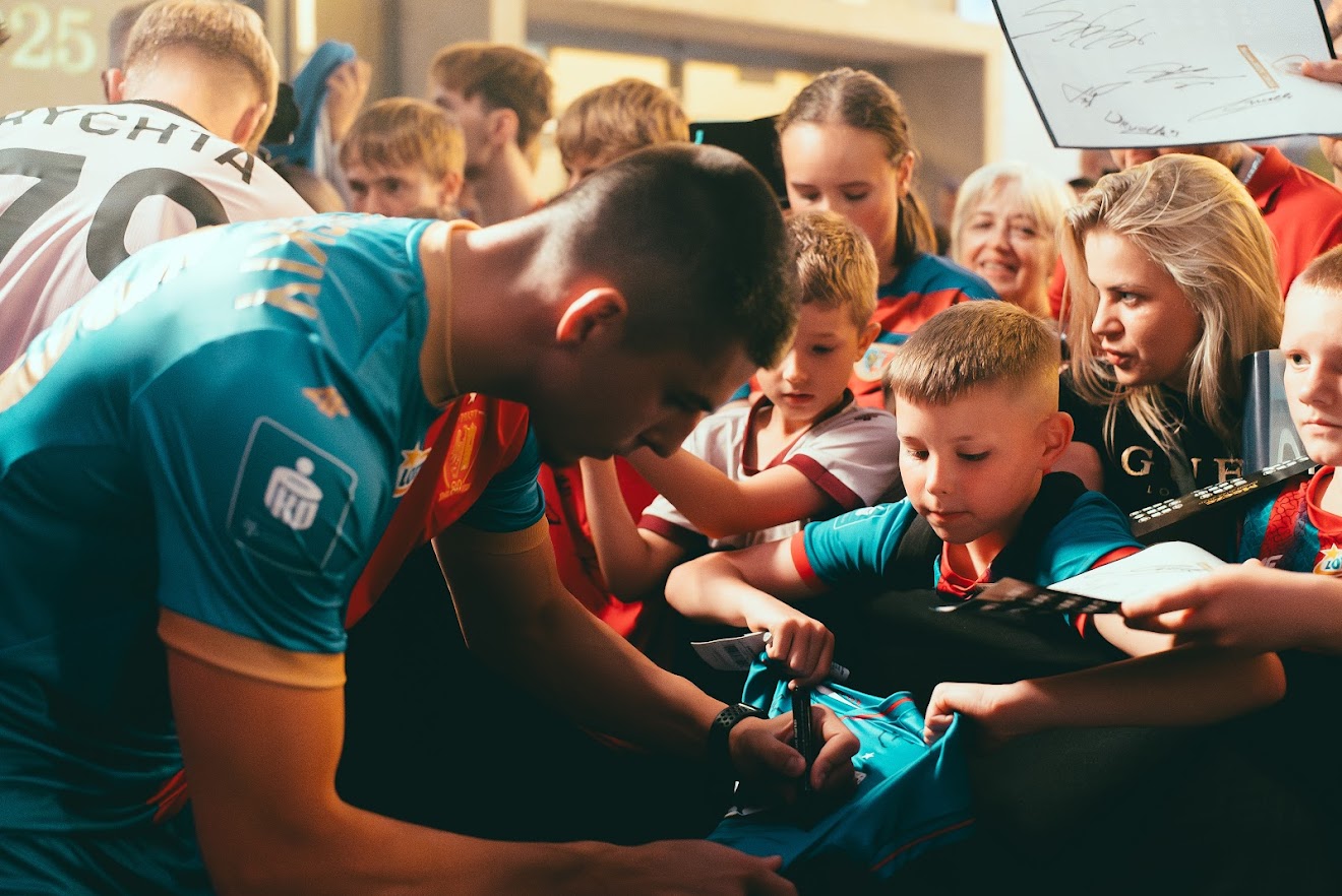 Piłkarze rozdający autografy