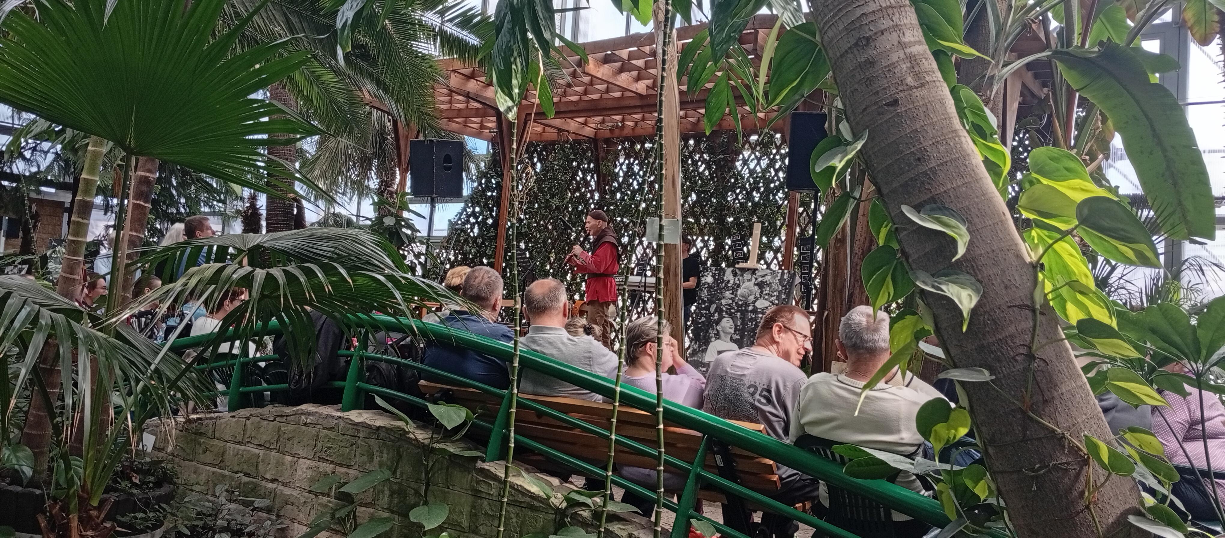Palmiarnia, dużo zieleni, w głębi wystepy na scenie