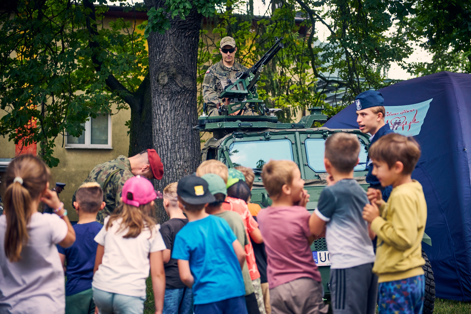 dzieci przy wozach służb mundurowych i wojskowi