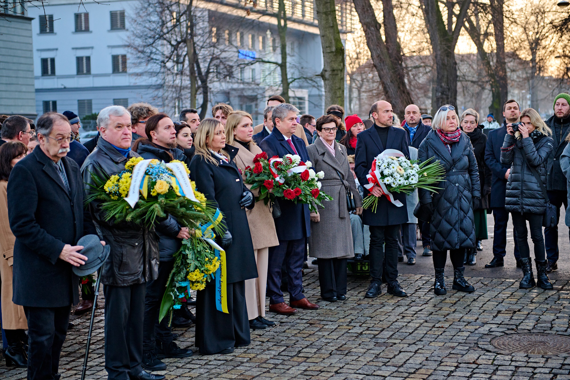 Uczestnicy obchodów z kwiatami w rękach