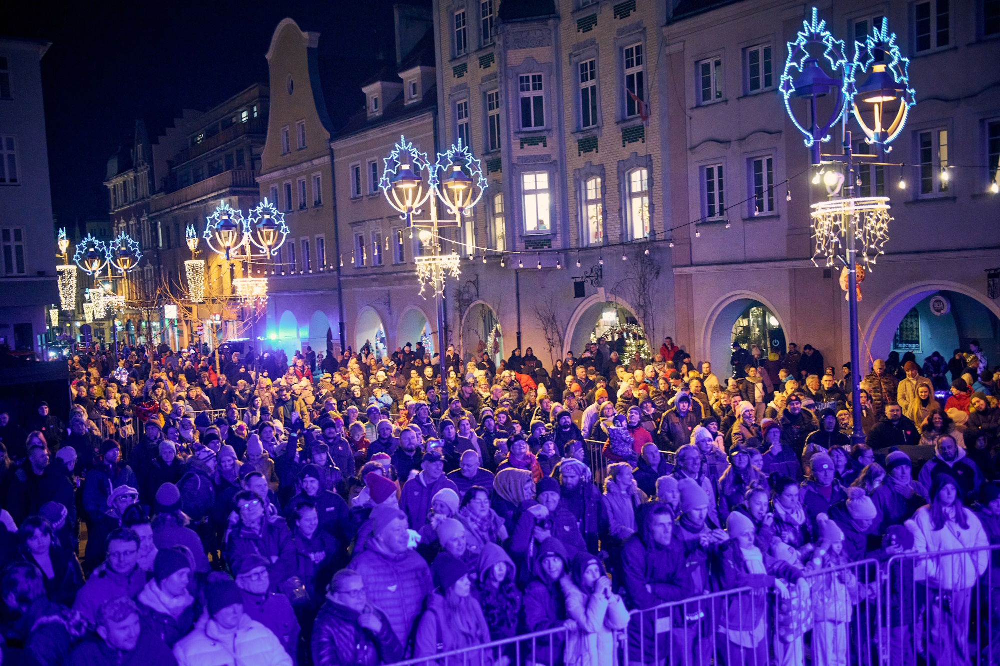 Ludzie za barierkami pod sceną