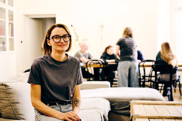 Małgorzata Paszkowska siedzi na kanapie, w tle jej rodzina